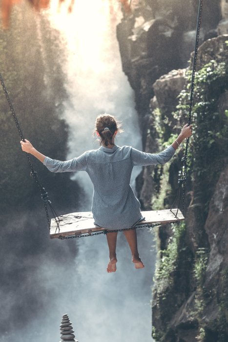 an image of a woman swinging above a ravine