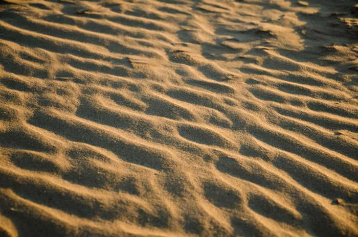 A close up photo of textured sand