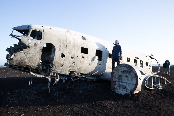 picture of man on the wing of an abandoned plane wreck, part of Iceland's Ghost Fleet