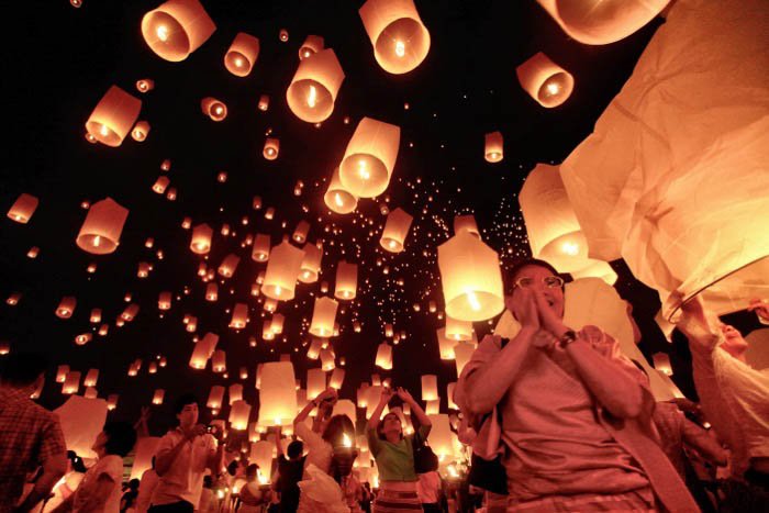 Hundreds of floating candles drift into the dark sky - travel photography