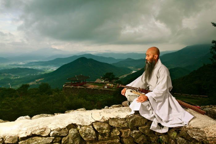 an image of a monk with hills in the background - travel photography