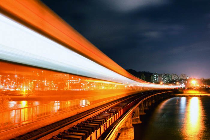 A long exposure of a train passing infront of a city