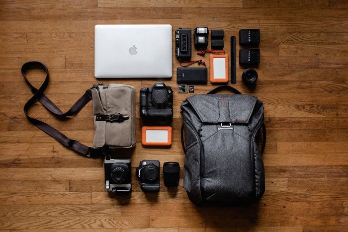 a flat lay of a travel camera bag and its items