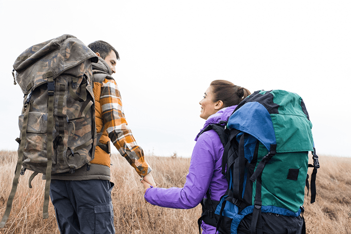 Couple walking with camera backpacks for hiking