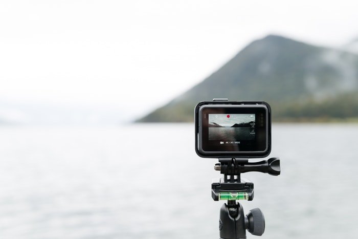 A GoPro on a tripod in front of a lake