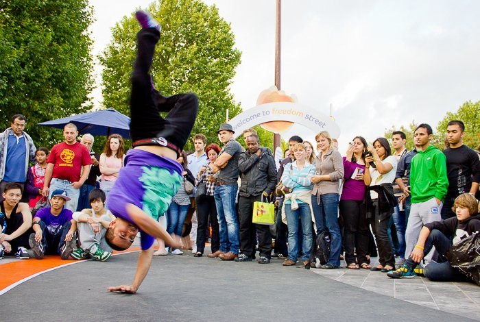 A guy break dancing at the Thames Festival with a crowd watching