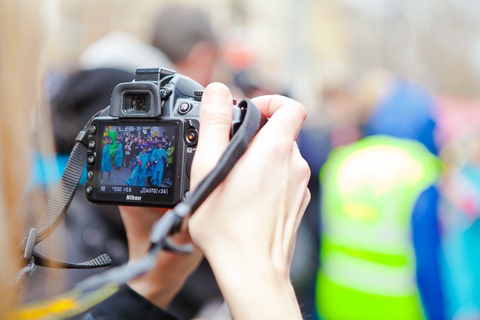 Close up of someone with a DSLR photographing a festival