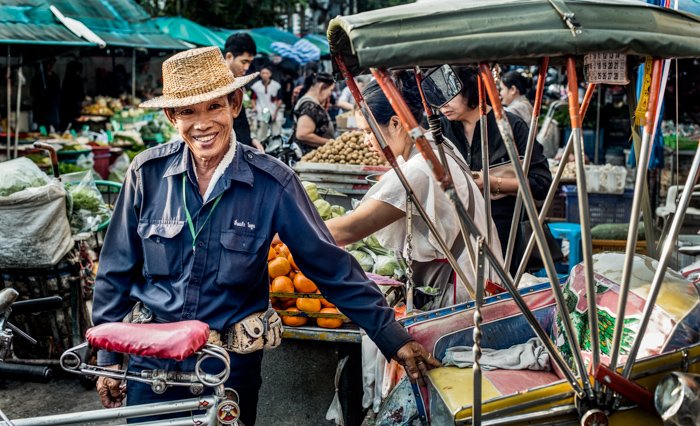 A samlar rider poses beside his vehicle