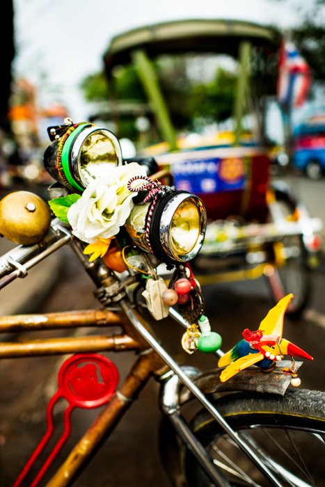 A close up of a bicycle light, adorned with brightly colored decorations - documentary photography tips