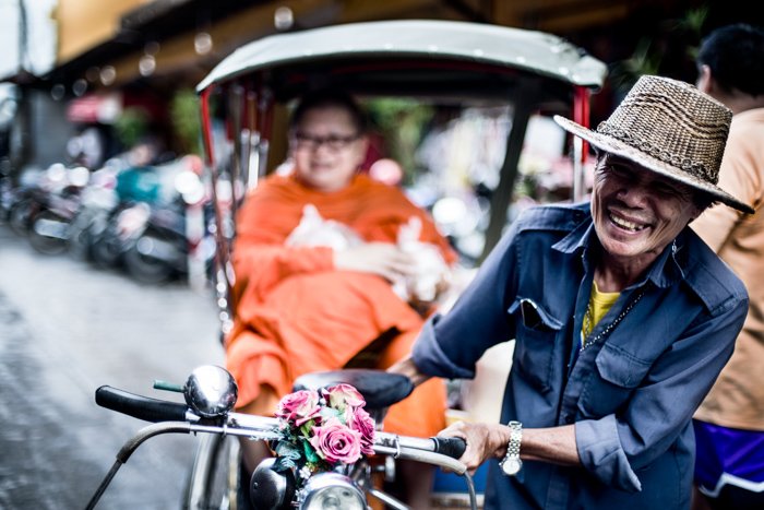 Documentary photography portrait of a saamlor rider and a monk in a Market in Chiang Mai, Thailand.
