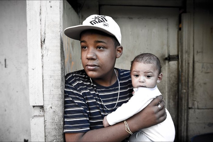 Portrait of a young man holding a small baby - local guide for better travel photography