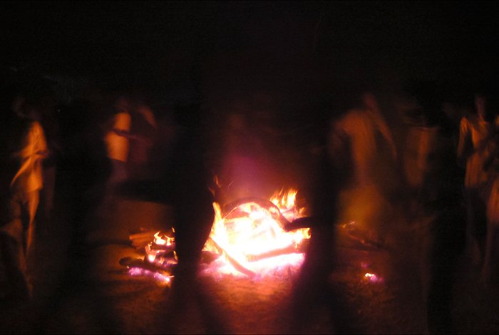 Atmospheric travel photography shot of people dancing around a fire