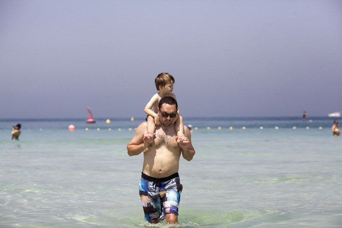 A father and son walking in the ocean