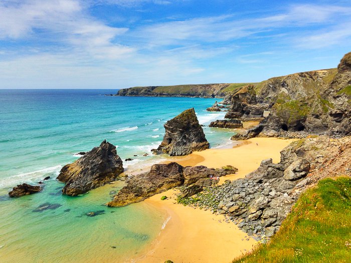 a rocky beach extending into the deep blue waters at a beach