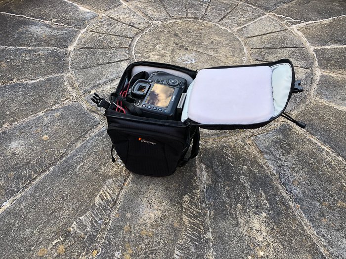 a toploader DSLR camera bag on stone ground