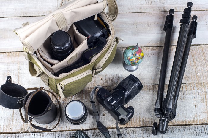 A camera bag and accessories on wooden boards