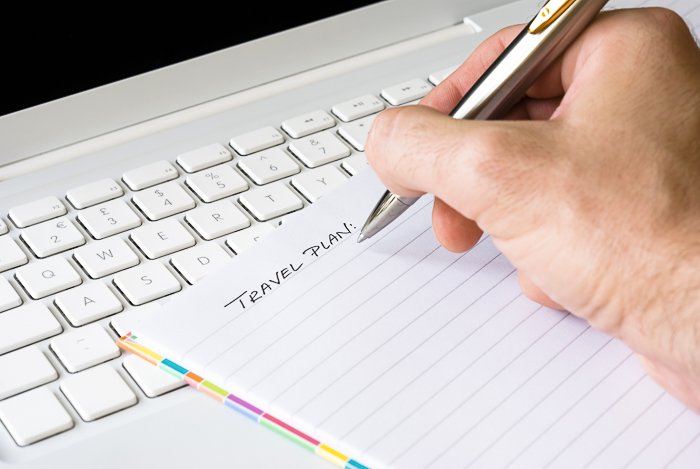 Close up of a person writing a travel photography plan